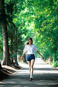 女孩走在林荫小道上图片