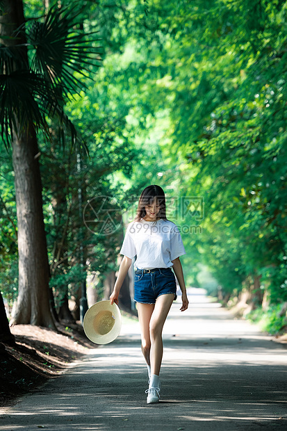 女孩走在林荫小道上图片