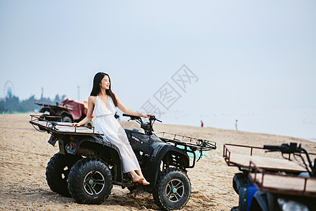 沙地摩托海边坐沙滩车的美女背景