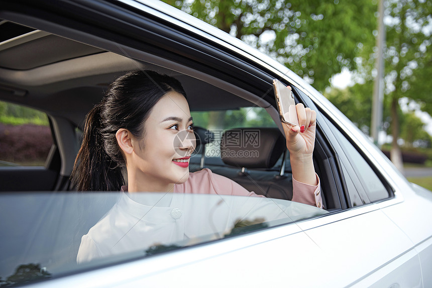 年轻女性在车内用手机拍照图片