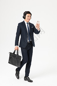 商务男性走路戴耳机背景图片