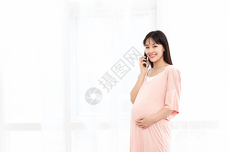 孕妇在客厅纱窗旁边使用手机打电话背景图片