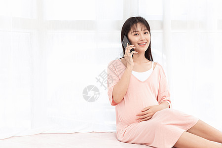 孕妇在客厅纱窗旁边使用手机打电话背景图片