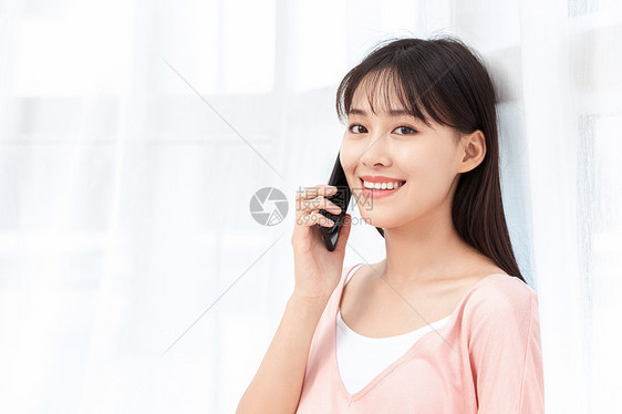 孕妇在客厅纱窗旁边使用手机打电话图片