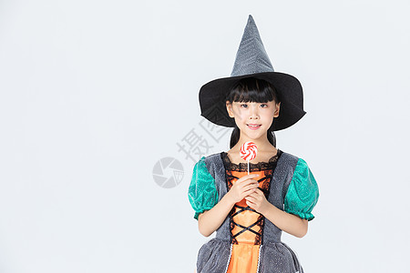 可爱小女孩万圣节女巫打扮拿着棒棒糖背景图片
