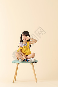 小女孩坐在椅子上害羞挡眼睛图片