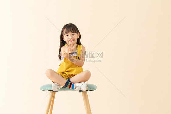 小女孩坐在椅子上微笑伸手图片