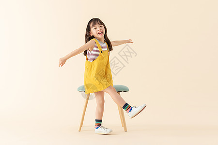 可爱小美女在站在椅子旁边图片