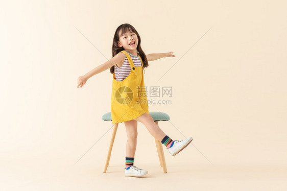 可爱小美女在站在椅子旁边图片