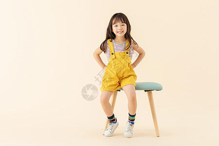 可爱小女孩坐在椅子上叉腰图片