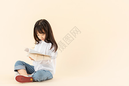 小女孩坐在地上看书图片