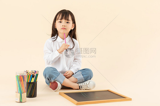 小女孩坐在地上画画图片