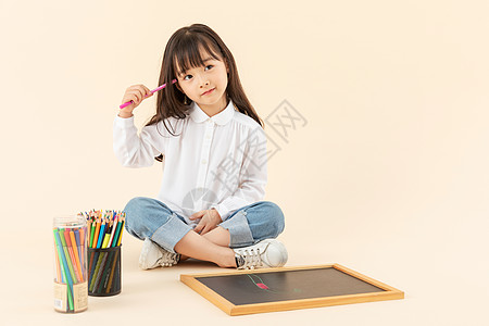 小女孩坐在地上画画图片
