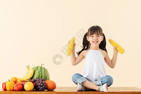 小女孩手拿蔬菜小女孩手拿玉米背景