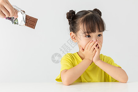 捂嘴的小女孩小女孩拒绝吃被人给的巧克力背景