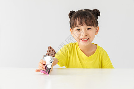 小女孩开心的吃着巧克力高清图片