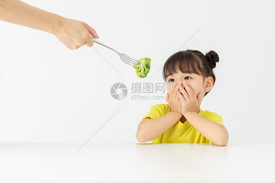 小女孩捂嘴拒绝吃别人喂的食物图片