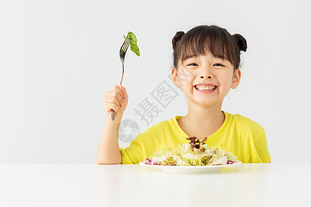 吃早餐的女孩小女孩开心的吃着蔬菜沙拉背景
