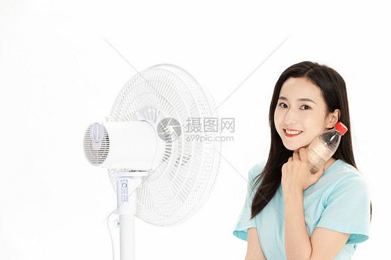 夏日美女拿矿泉水吹风扇图片