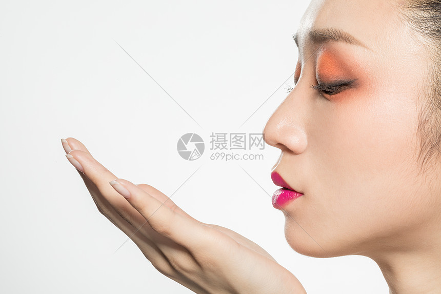 女性侧脸往手吹气