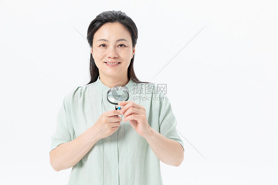 中年女性放大镜看药品图片