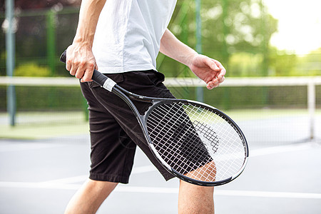 青年男性网球场打网球背景图片
