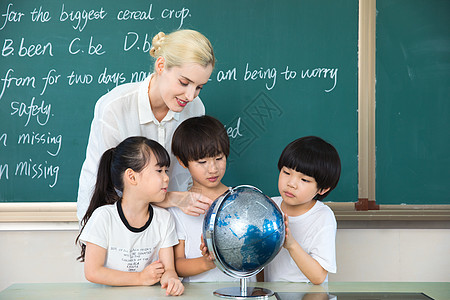 中国人外国人外教老师带着学生了解地球仪背景