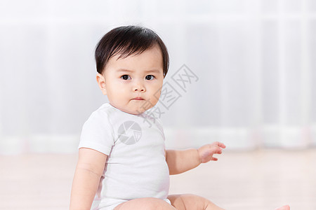 婴儿坐在地板上背景图片