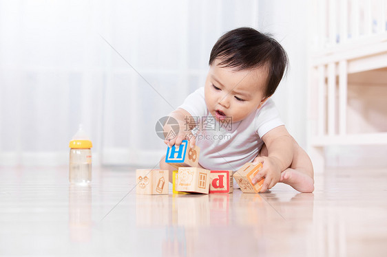 婴儿坐在地板上玩耍图片
