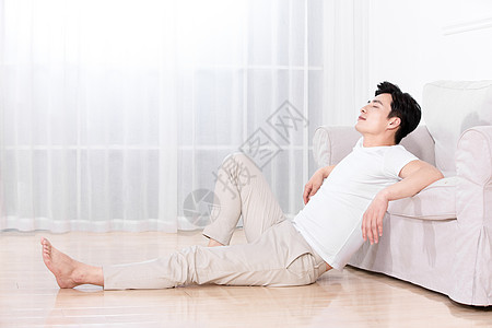 男性靠在沙发上休息图片