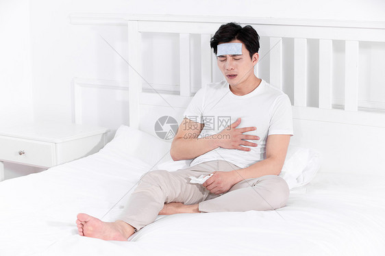 男子发烧感冒靠在床上休息正侧面图片