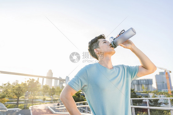 男性户外运动间隙喝水图片