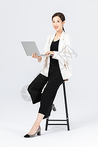 魅力女性坐在高脚椅上的商务女性看笔记本电脑背景