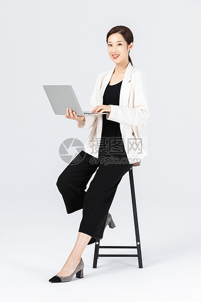坐在高脚椅上的商务女性看笔记本电脑图片