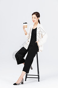 坐在高脚椅上喝咖啡的自信女性图片