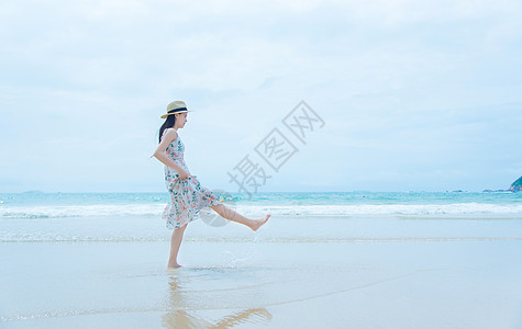 深圳西冲沙滩上的少女玩水高清图片