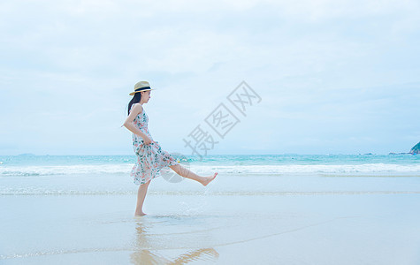深圳西冲沙滩上的少女玩水背景图片