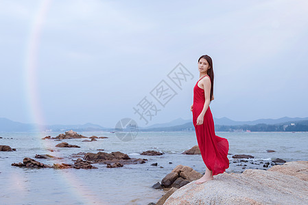 深圳较场尾海边礁石上的红衣少女图片