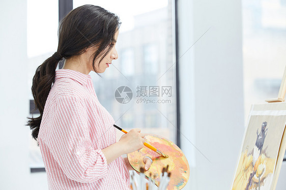 美女画家认真绘画侧面图片