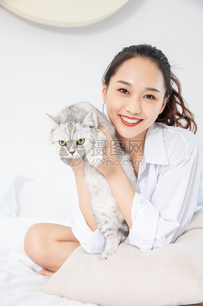 年轻美女和宠物猫在家嬉戏图片