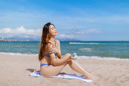 海边美女涂抹防晒霜图片