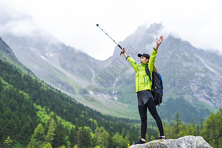 户外爬山户外登山杖运动的女生背景