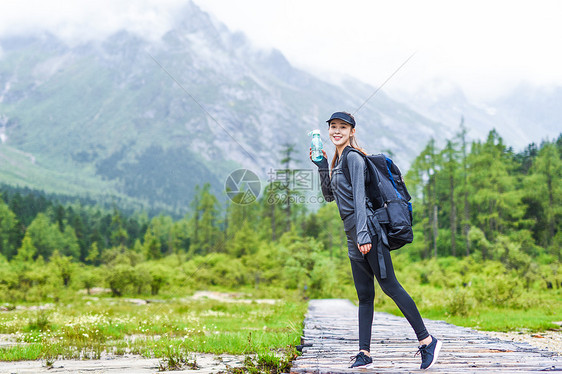 户外登山美女喝水休息图片