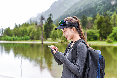 登山玩手机的女生背景图片