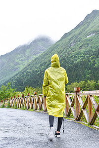雨天的徒步穿雨衣的女生背景
