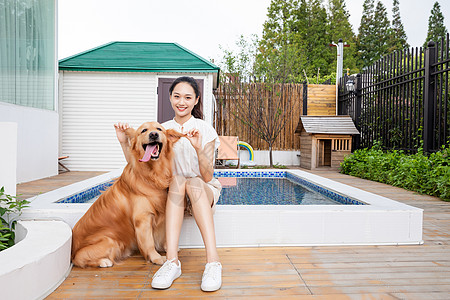 年轻美女与宠物狗院子里嬉戏背景