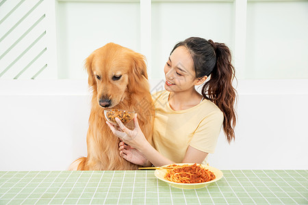 美女主人和宠物狗一起吃饭图片