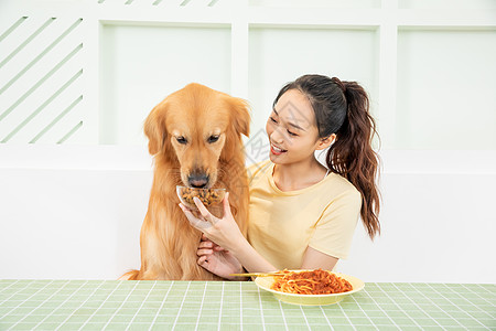 美女主人和宠物狗一起吃饭高清图片