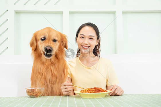 美女主人和宠物狗一起吃饭图片