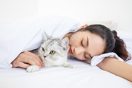 蜂蜜美女美女抱着宠物猫睡觉背景